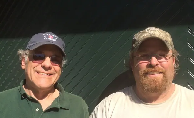 Rick Mignone and Vic of Garage Doors by Rick Mignone, in front of a garage door